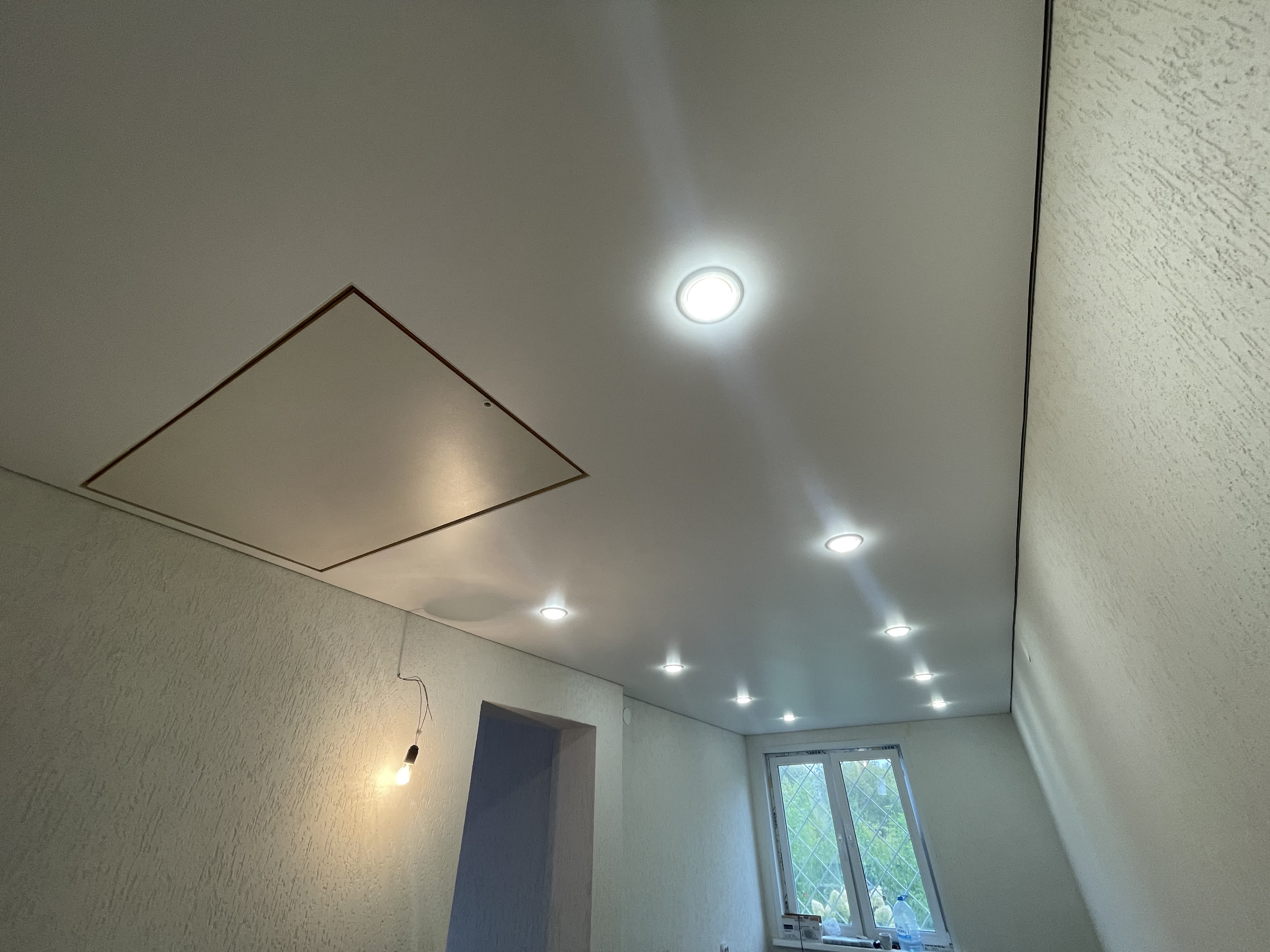 Белый матовый натяжной потолок с входом на чердак