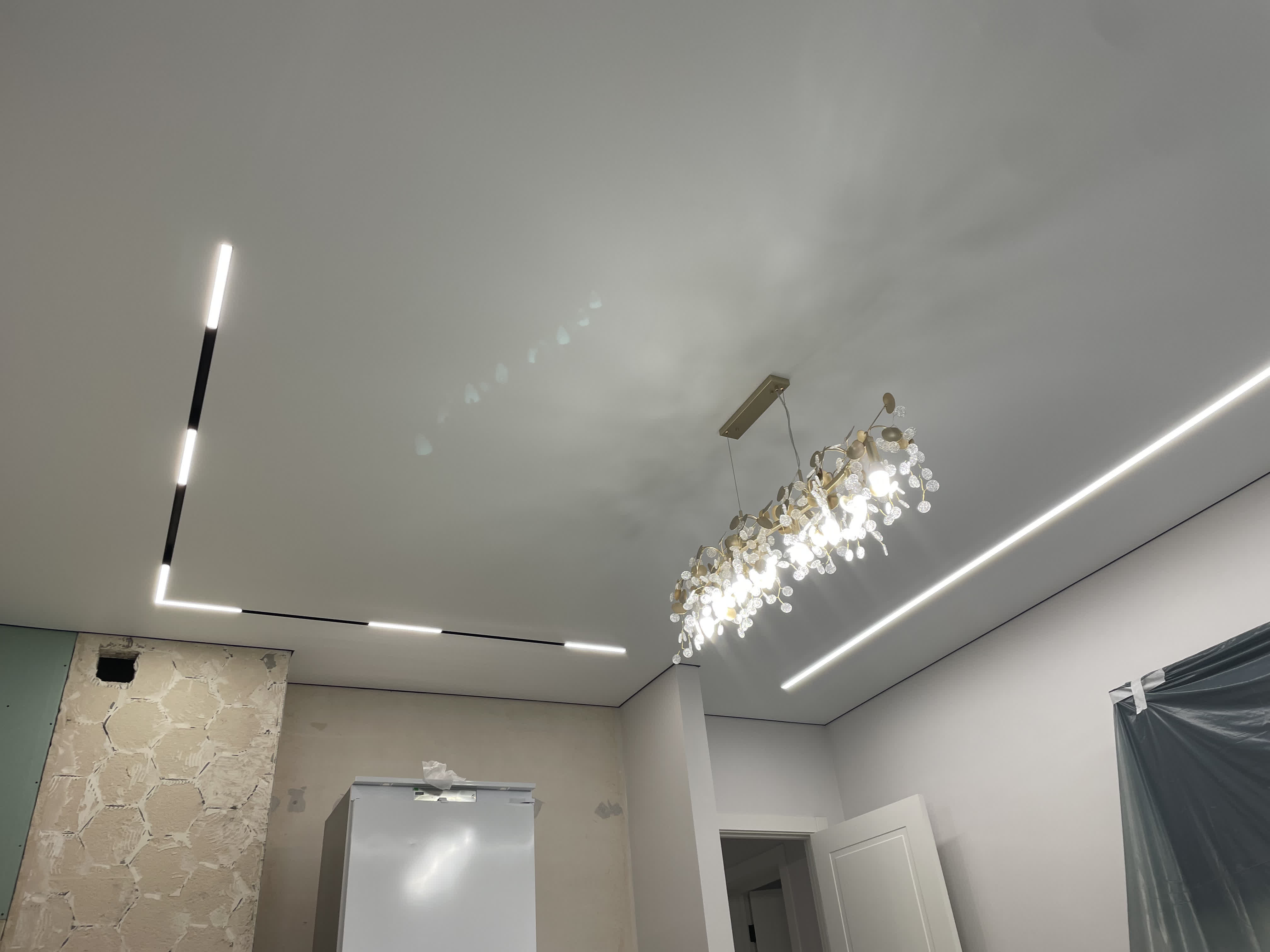 Белый матовый натяжной потолок с свисающим светильником на кухне