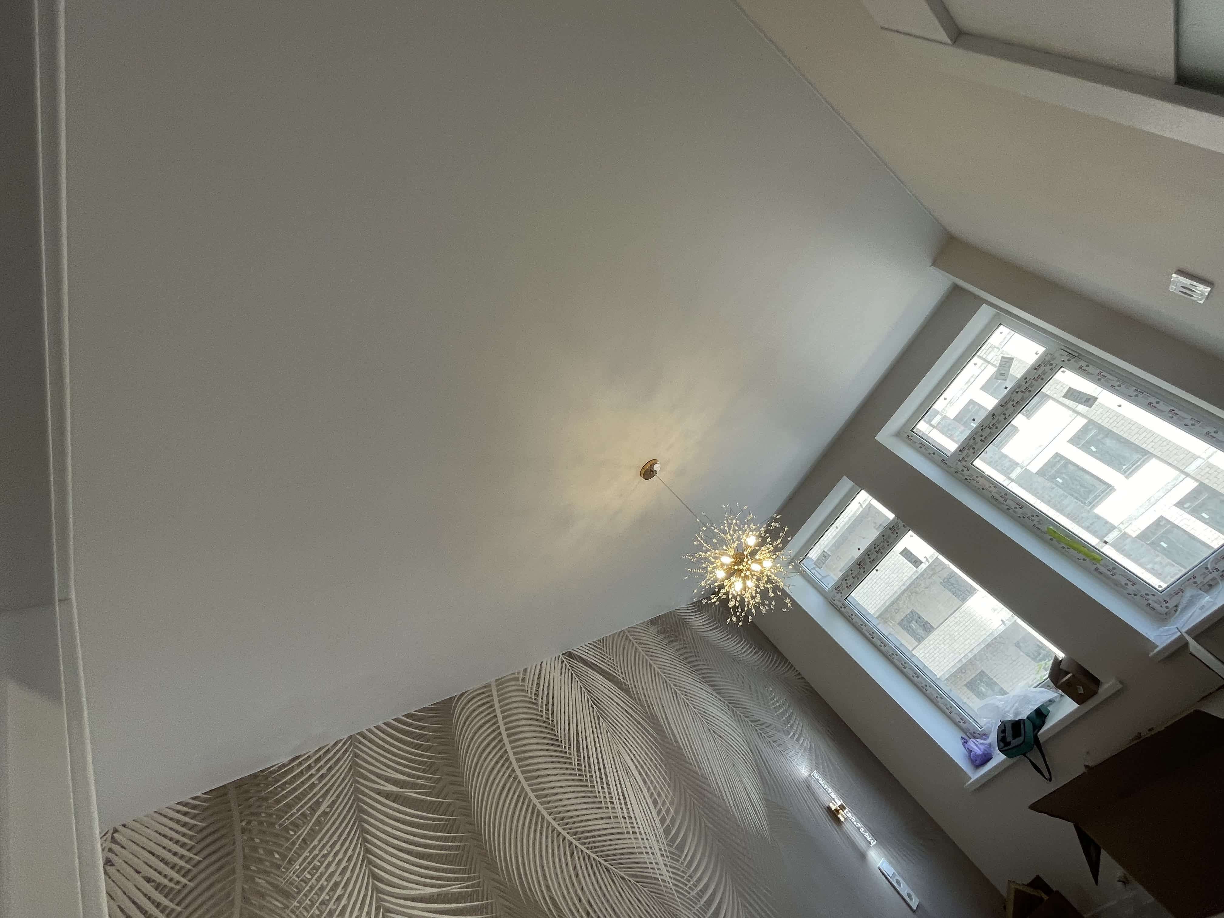 Белый матовый натяжной потолок с свисающим светильником