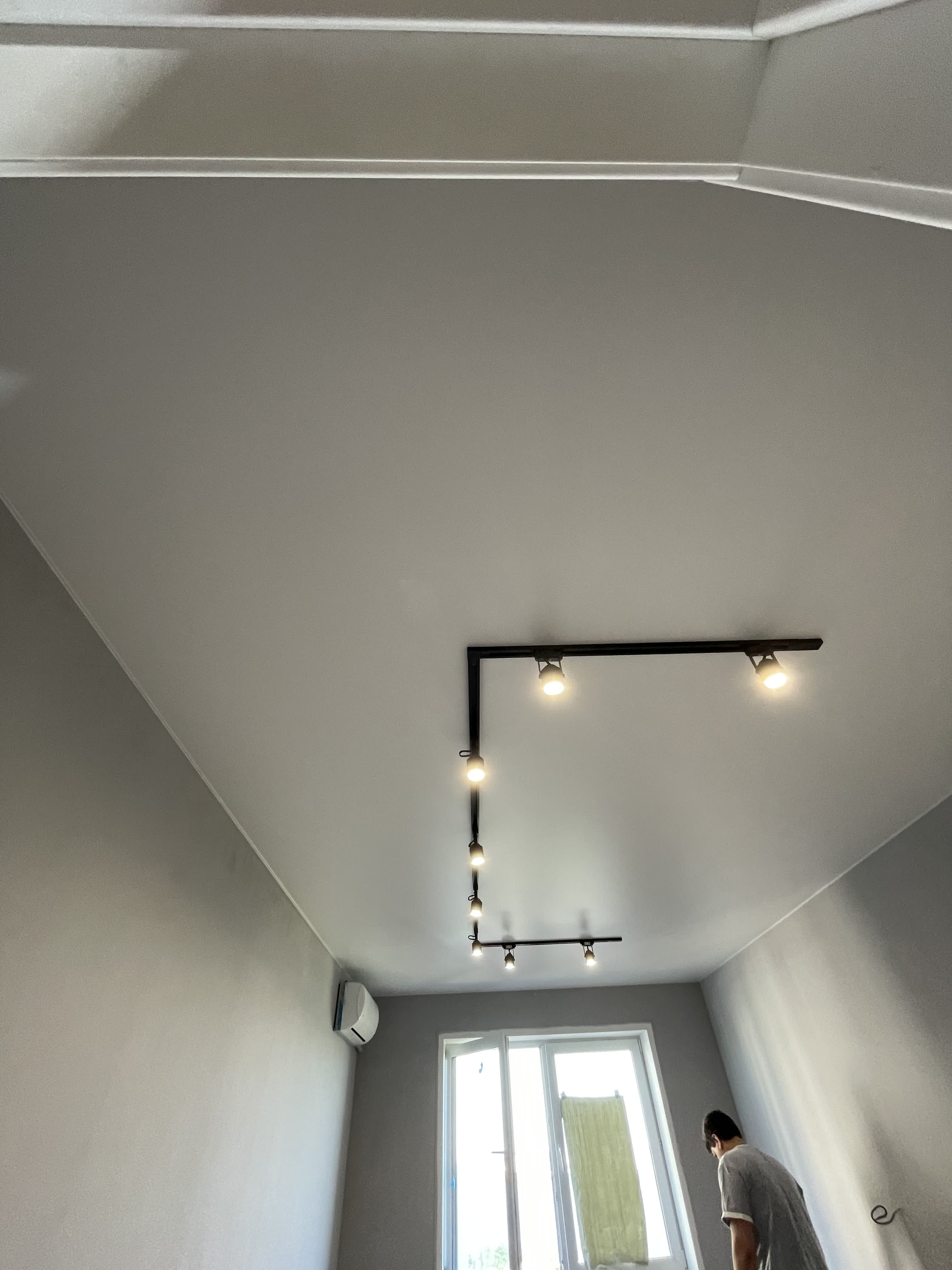 Белый матовый натяжной потолок с черными металлическим светильником