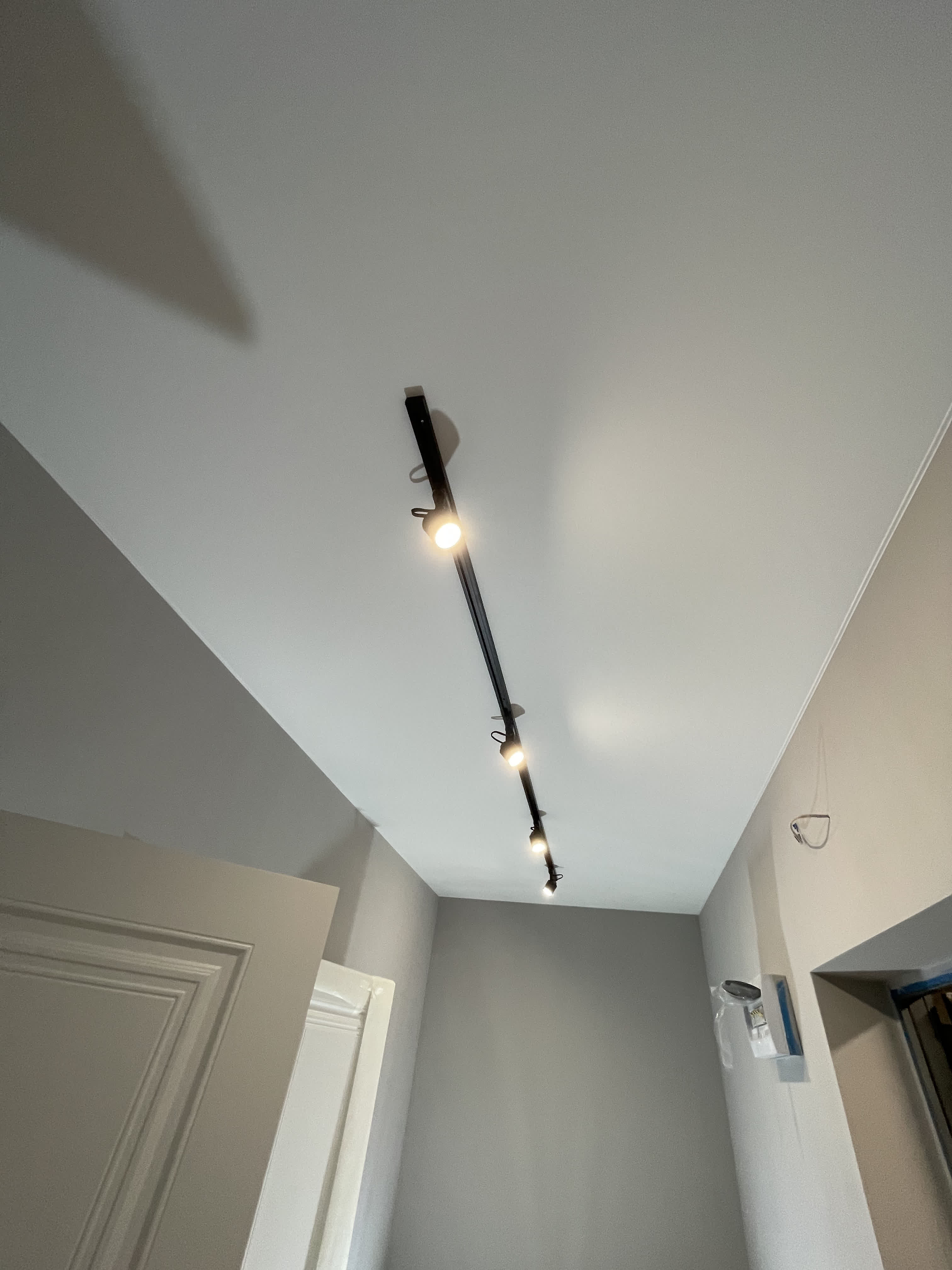 Белый матовый натяжной потолок с металлическим светильником прямым